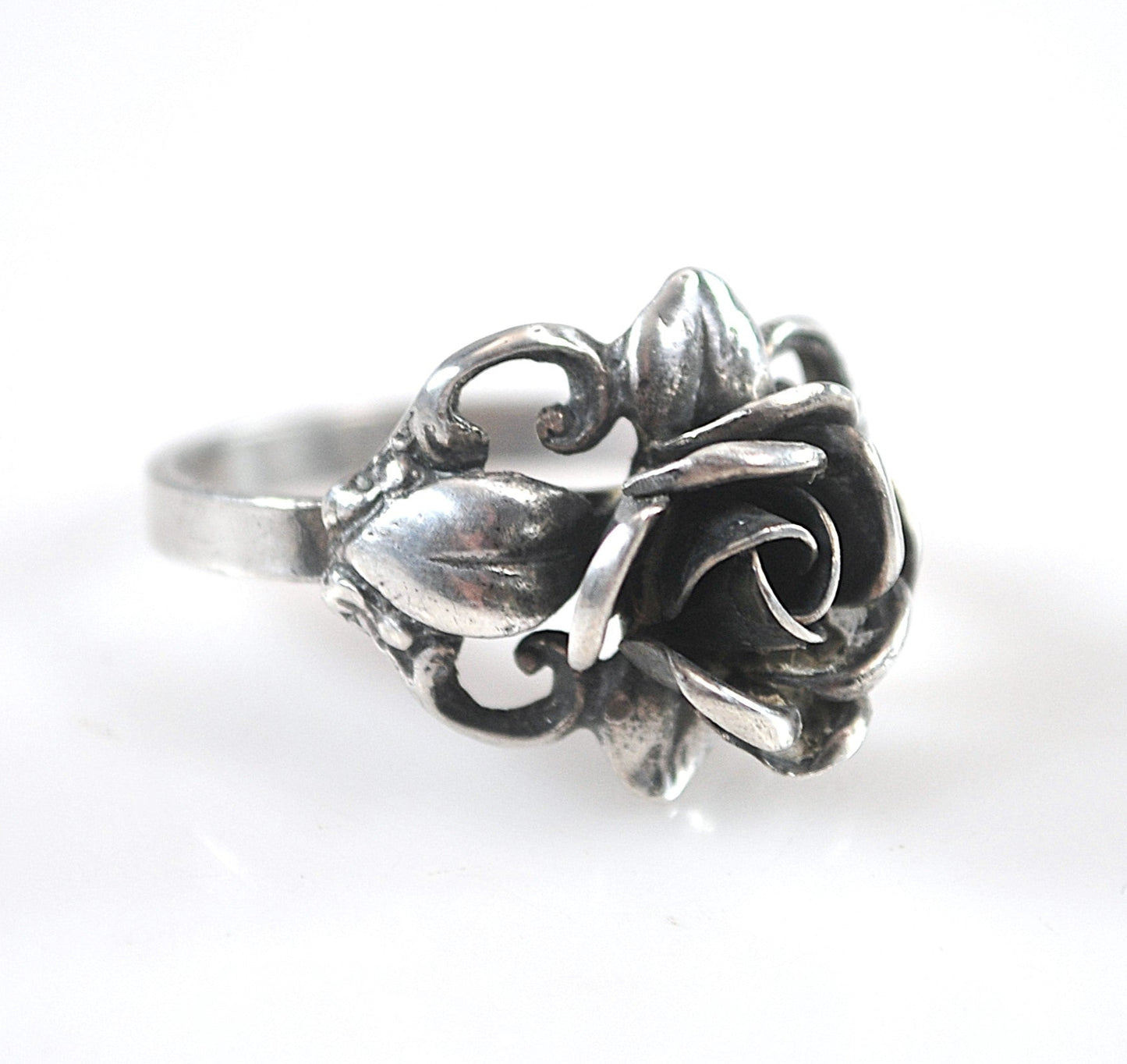 Silver ring with floral design on a white background