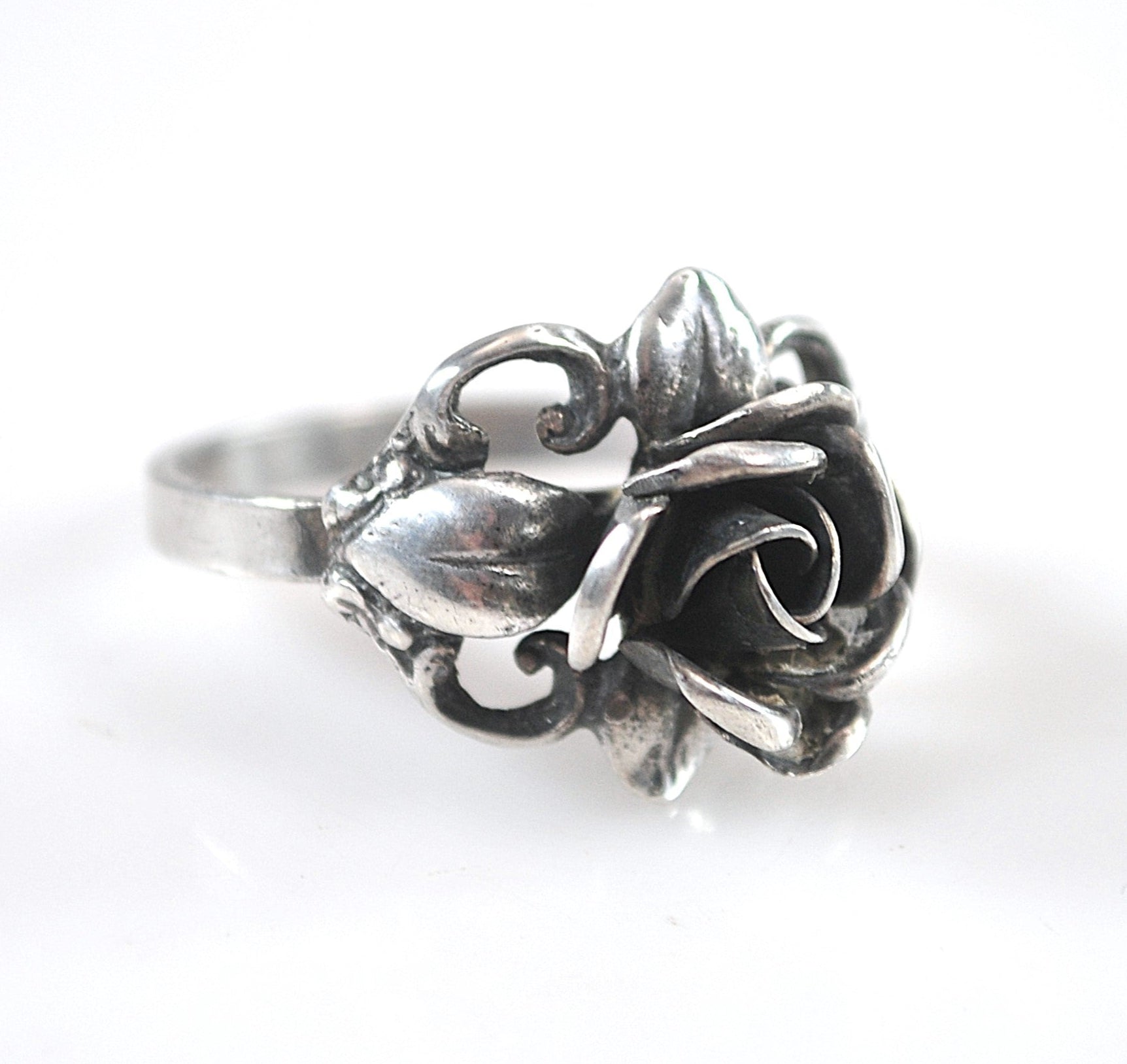 Silver ring with floral design on a white background